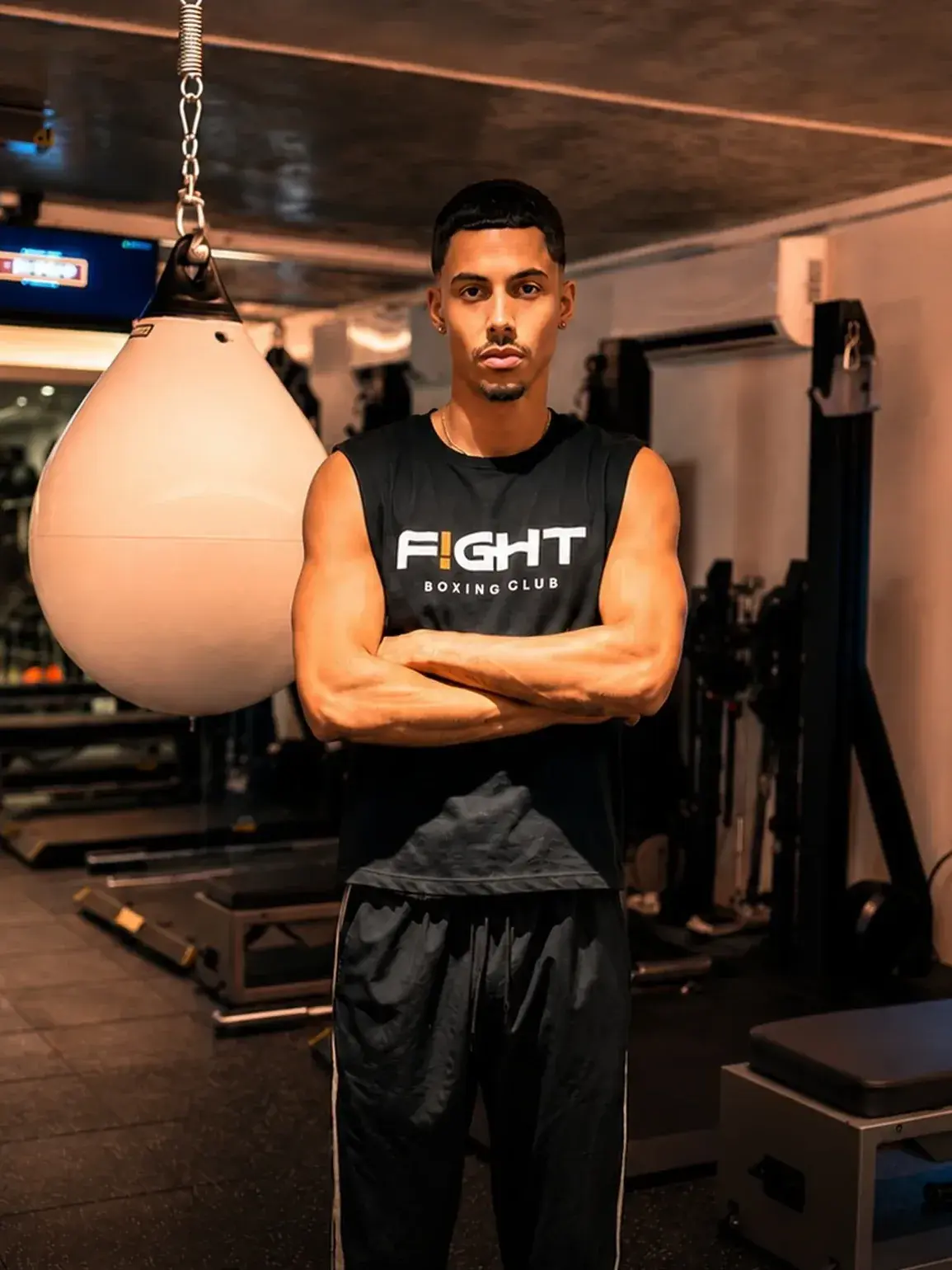 Jorge, head trainer at F!GHT BOX, standing beside an aqua bag in the Condado studio